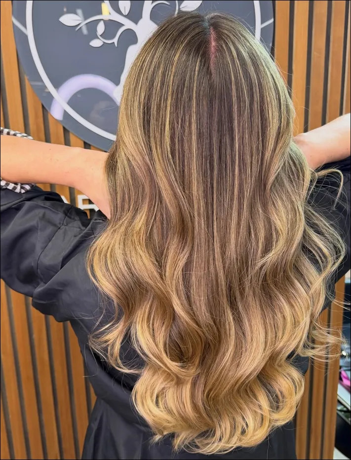 Cabello largo con ondas y reflejos dorados en el salón María Bonita